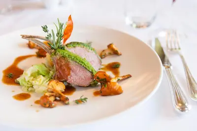 a white plate with food on a table at Dependance Hotel Mareo Dolomites in San Vigilio Di Marebbe