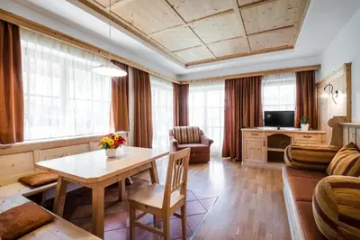 a living room with a table and a couch at Dependance Hotel Mareo Dolomites in San Vigilio Di Marebbe