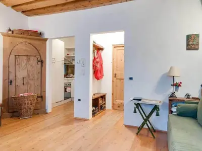 a living room with a green couch and an open door at Modern Apartment, Bressanone in Bressanone