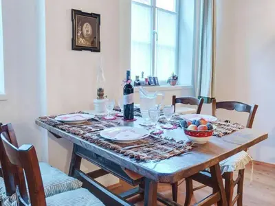 a table with a bottle of wine and a bowl of fruit at Modern Apartment, Bressanone in Bressanone