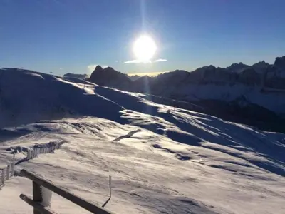 a snow covered mountain with the sun in the sky at Modern Apartment, Bressanone in Bressanone