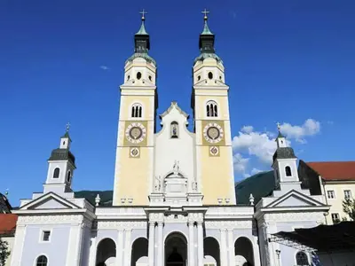 a large white building with two towers with clocks on it at Modern Apartment, Bressanone in Bressanone