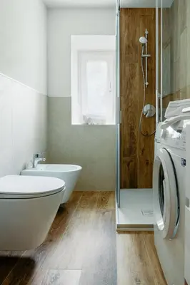 a bathroom with a washing machine and a sink at Ciasa Silvano 1721 SV in Falcade