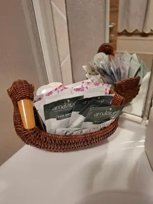 a basket of toiletries on a counter in front of a mirror at Appartamento Sot le Pale in Taibon