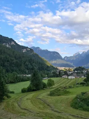 a green field with mountains in the background at Appartamento Sot le Pale in Taibon