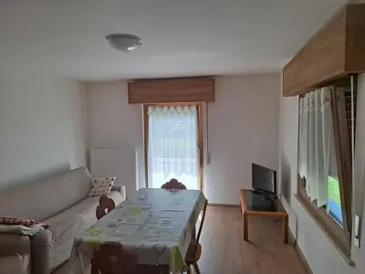 a living room with a couch and a tv at Appartamento Sot le Pale in Taibon