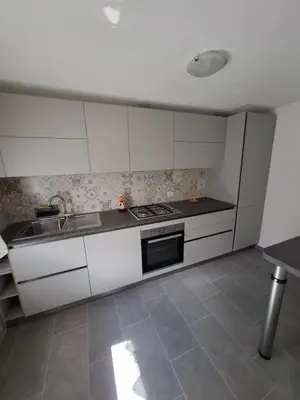 a kitchen with white cabinets and a sink and a stove at Appartamento Sot le Pale in Taibon