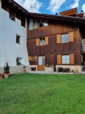 an exterior view of a house with a yard at Fienile contemporaneo in Livo