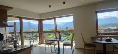 a kitchen with a table and chairs and windows at Highlight Apartments in Appiano sulla Strada del Vino