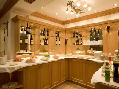 a restaurant with many plates of food and bottles of wine at Hotel Christian in Corvara in Badia