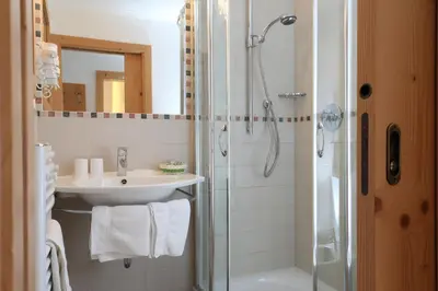 a bathroom with a sink and a shower at Hotel Christian in Corvara in Badia