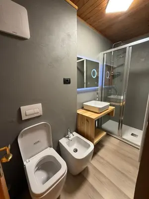 a bathroom with a toilet and a sink and a shower at Appartamento DOLOMITES con BOX privato in Canazei