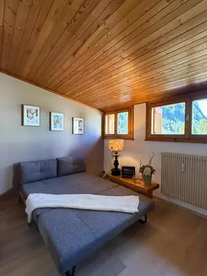a bedroom with a bed with a wooden ceiling at Appartamento DOLOMITES con BOX privato in Canazei