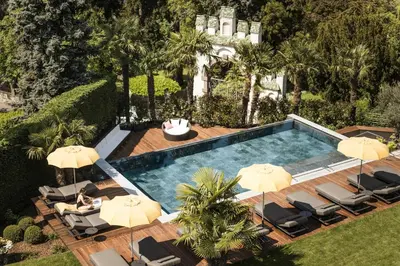 an aerial view of a swimming pool with umbrellas at Hotel Sonnenburg in Merano