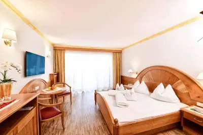 a hotel room with a bed and a desk at Hotel Sonnenburg in Merano