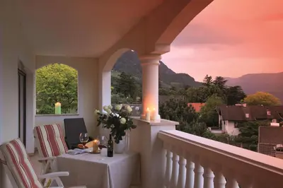 a balcony with a table with candles and a view at Hotel Sonnenburg in Merano