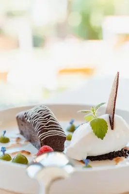 two desserts on a plate with a piece of cake at Hotel Sonnenburg in Merano