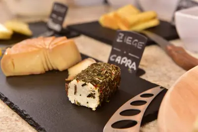 a plate of food with a piece of cake and cheese at Hotel Sonnenburg in Merano