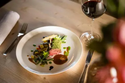 a person is cooking food in a pan at Mirabell Dolomites Hotel in Valdaora