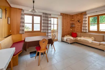 a living room with a table and a couch at Thalerhof in Feldthurns