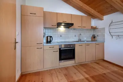 a kitchen with wooden cabinets and a sink and a stove at Thalerhof in Feldthurns