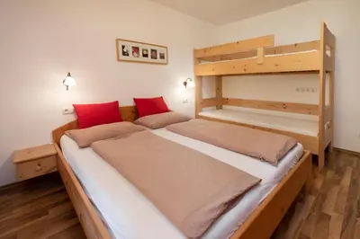 two beds in a room with two bunk beds at Thalerhof in Feldthurns