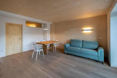 a living room with a blue couch and a table at Thalerhof in Feldthurns