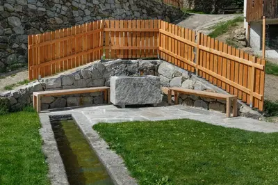a park with two benches and a wooden fence at Thalerhof in Feldthurns