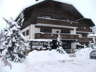 a snow covered building with a sign in front of it at Carezza Lake Apartment in Carezza al Lago