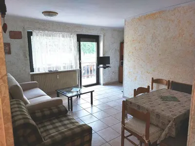 a living room with a couch and a table at Carezza Lake Apartment in Carezza al Lago