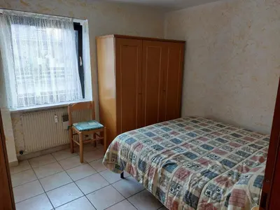 a bedroom with a bed and a cabinet and a chair at Carezza Lake Apartment in Carezza al Lago