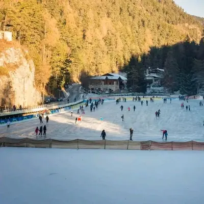 a group of people skating on a rink in the snow at Agritur Gioia in Sanzeno