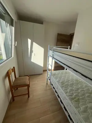 a bedroom with two bunk beds and a chair at Residenza Erica in Moena