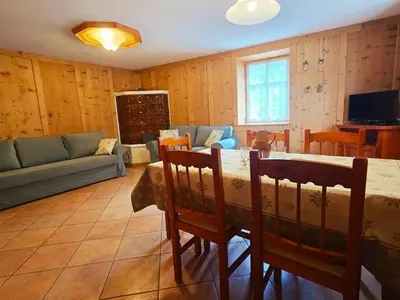 a living room with a table and chairs and a couch at La Fata di Moena - Alpine Stay Apartments in Moena