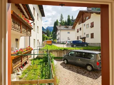 a window view of a car parked outside a building at La Fata di Moena - Alpine Stay Apartments in Moena