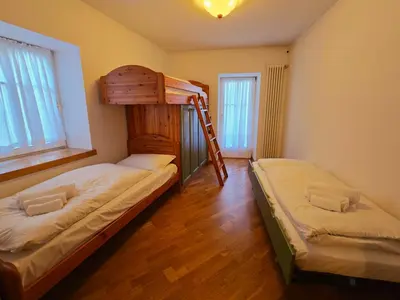 a bedroom with two bunk beds and a ladder at La Fata di Moena - Alpine Stay Apartments in Moena