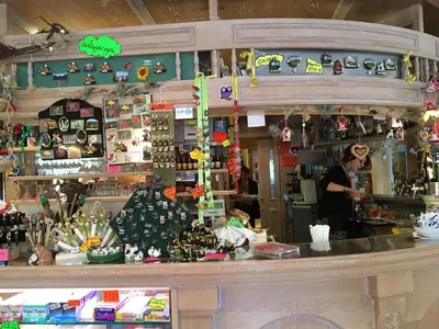 a woman standing behind a counter in a store at Albergo La Bicocca in Paneveggio