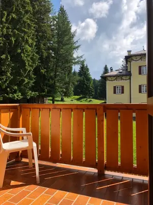 a white chair sitting on a deck with a fence at Albergo La Bicocca in Paneveggio