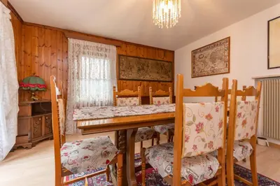 a room with a table and chairs and a dining room at Appartamento Alba sulle Dolomiti in Falcade