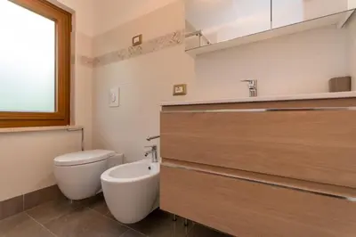 a bathroom with a toilet and a sink at Appartamento Alba sulle Dolomiti in Falcade