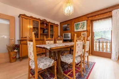 a dining room with a table and chairs at Appartamento Alba sulle Dolomiti in Falcade