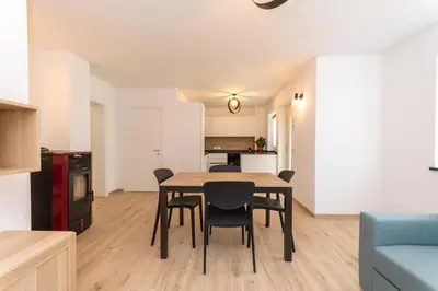 a kitchen and dining room with a table and chairs at Casa Serena in Dolomiti Agordine in Taibon