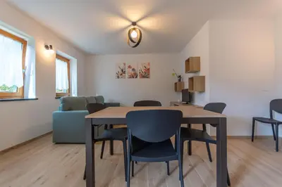 a dining room with a table and chairs at Casa Serena in Dolomiti Agordine in Taibon