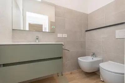 a bathroom with a sink and a toilet and a mirror at Casa Serena in Dolomiti Agordine in Taibon