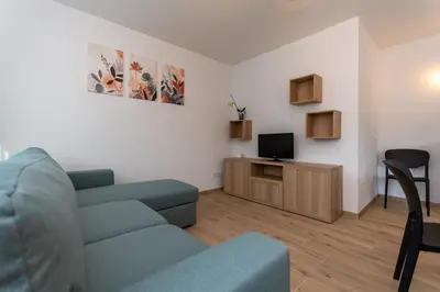 a living room with a blue couch and a tv at Casa Serena in Dolomiti Agordine in Taibon