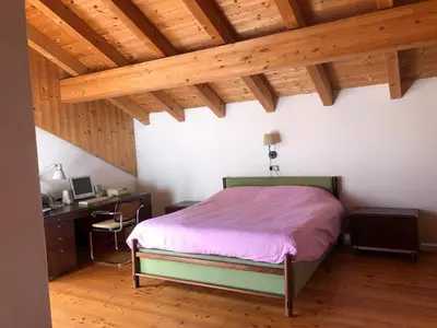 a bedroom with a bed and a desk and wooden ceilings at B&B del Mazarol in Canale San Bovo