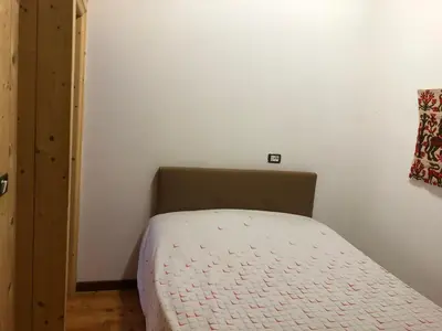 a small bedroom with a bed and a box at B&B del Mazarol in Canale San Bovo