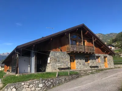 a large wooden house with a porch and a balcony at B&B del Mazarol in Canale San Bovo