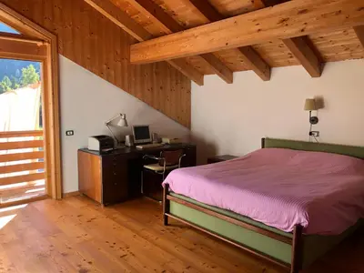 a bedroom with a bed and a desk with a computer at B&B del Mazarol in Canale San Bovo