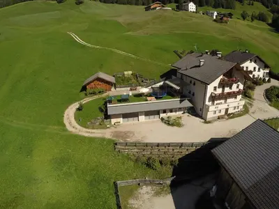 an aerial view of a large house on a green field at Wirthof in La Valle